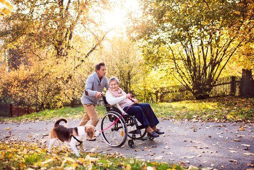 Example of random acts of kindness, a man helping an elderly woman who is wheelchair bound.